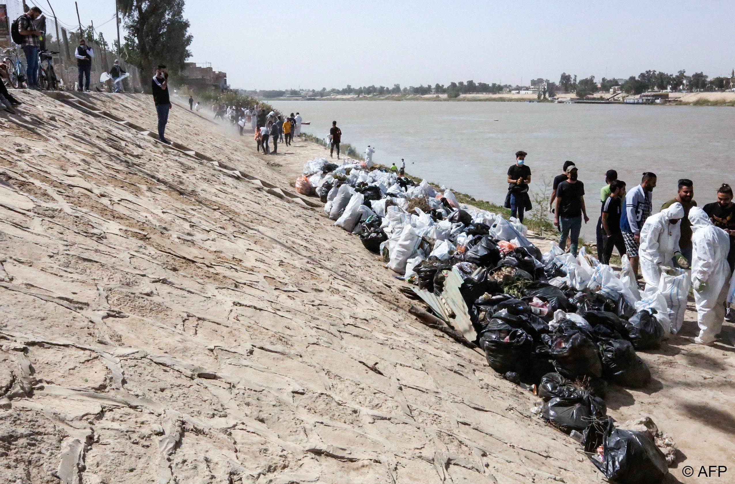 Young Iraqi volunteers take part in a cleanup campaign on the banks of the Tigris River, a rare environmental project in the war-battered country.