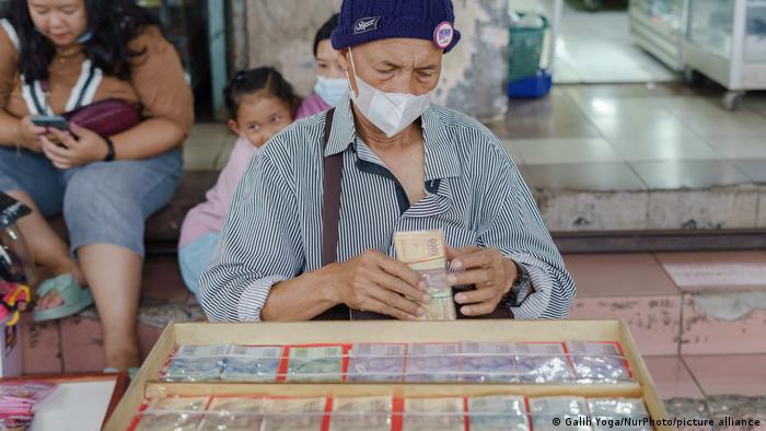 Mann bindet Geldscheine zu einem Päckchen zusammen