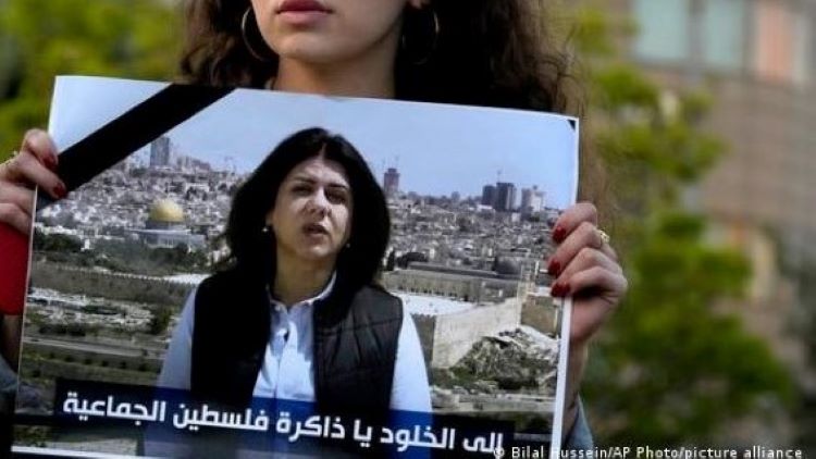 صحفية لبنانية تحمل صورة صحفية الجزيرة شيرين أبو عاقلة.