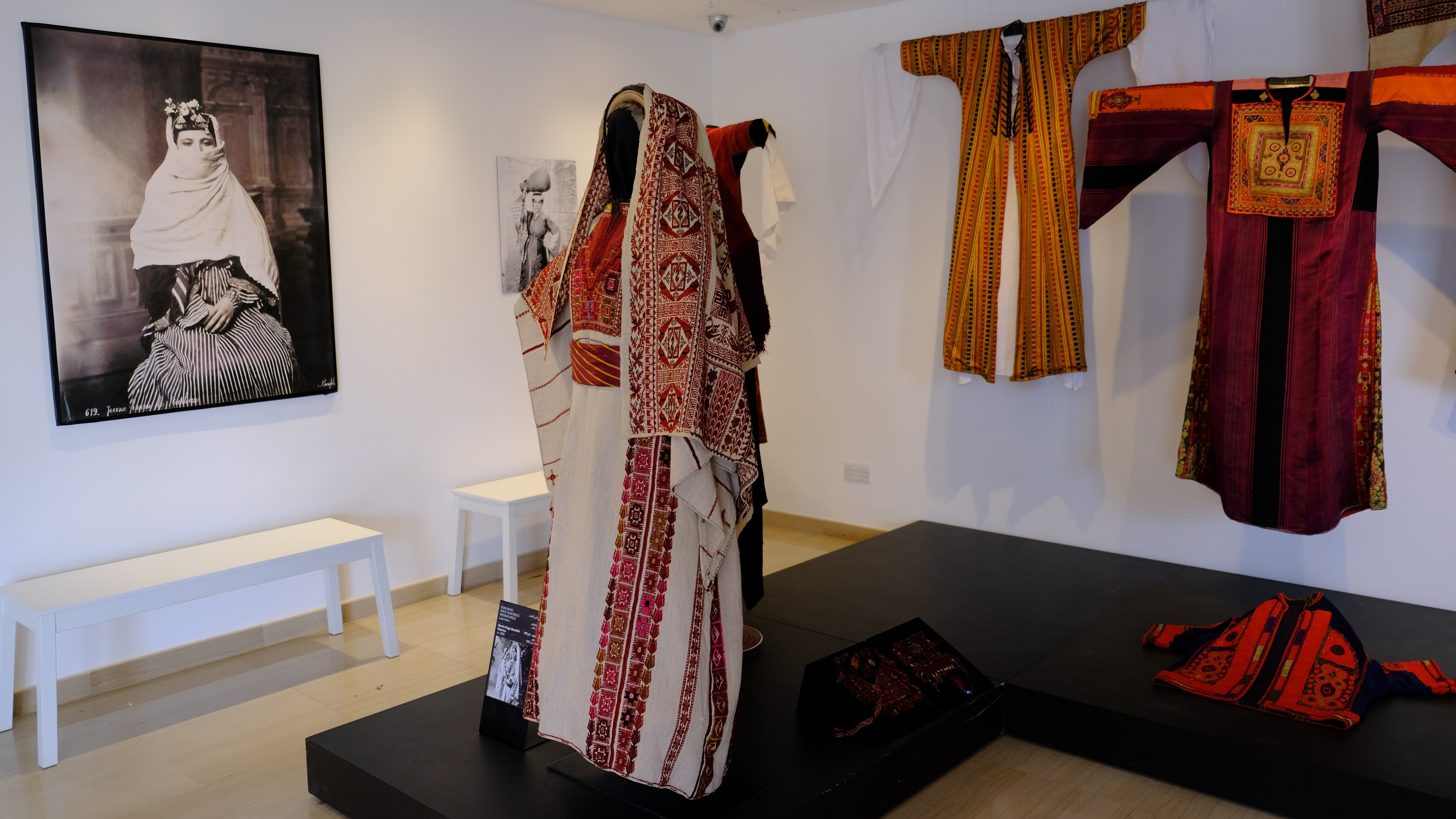 Exhibition space displaying Levantine costumes and an ancient photo of a women in traditional dress in Widad Kawar's Tiraz Museum (photo: Marta Vidal)