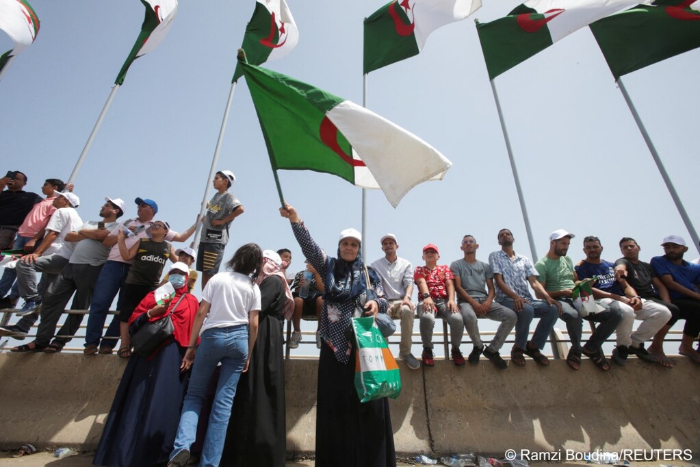 A woman waves the Algerian flag during a military parade to celebrate 60 years of Algeria's independence from France, 5 July 2022 (photo: REUTERS/Ramzi Boudina)