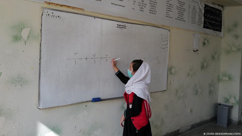 فتاة أفغانية تكتب على السبورة المدرسية في أفغانستان. Mädchen an der Schultafel in Afghanistan; Foto: Zohra Bensemra/Reuters