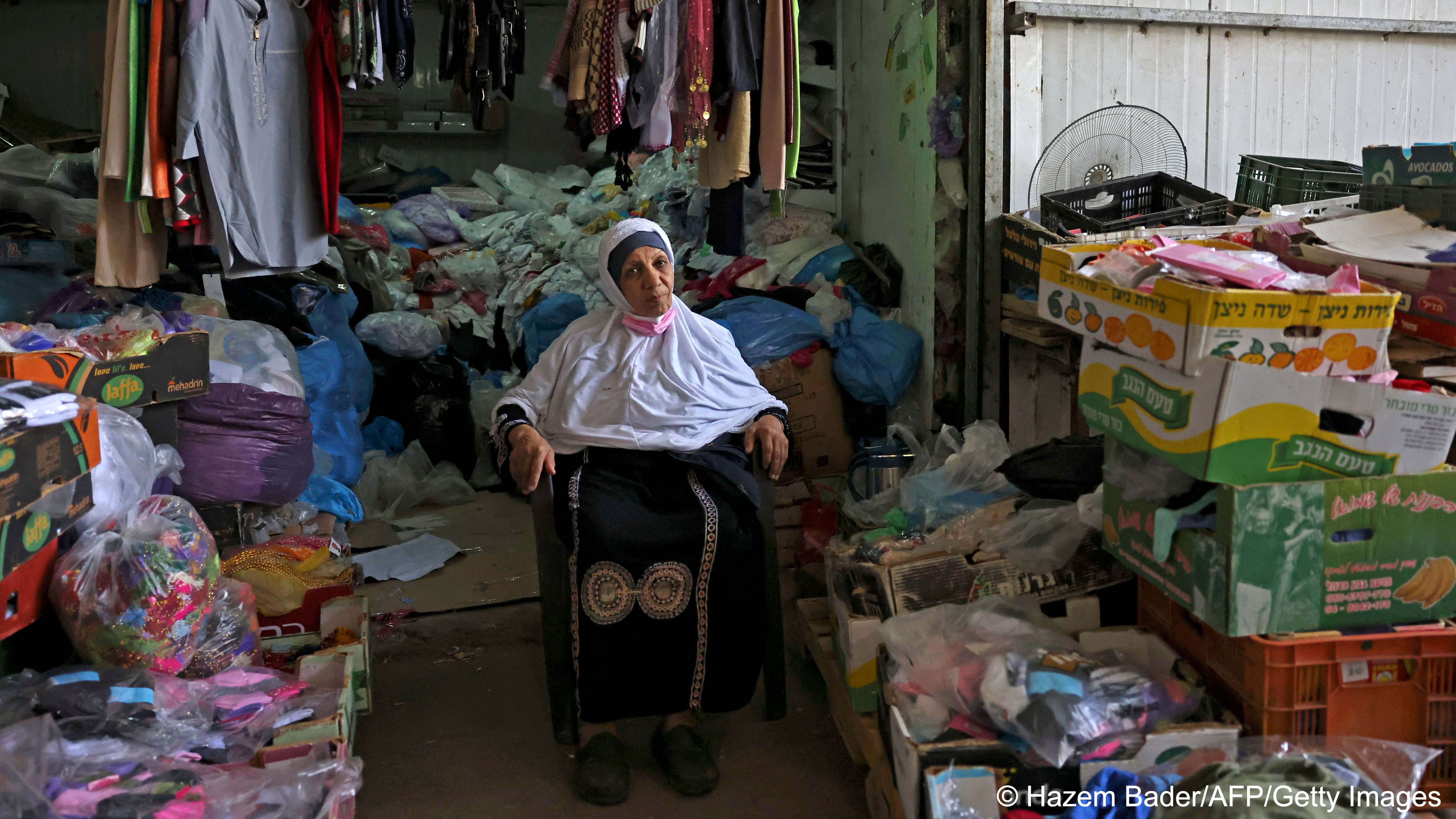 Woman sits on a chair at a stall in Rahat's central market (photo: HAZEM BADER/AFP) 