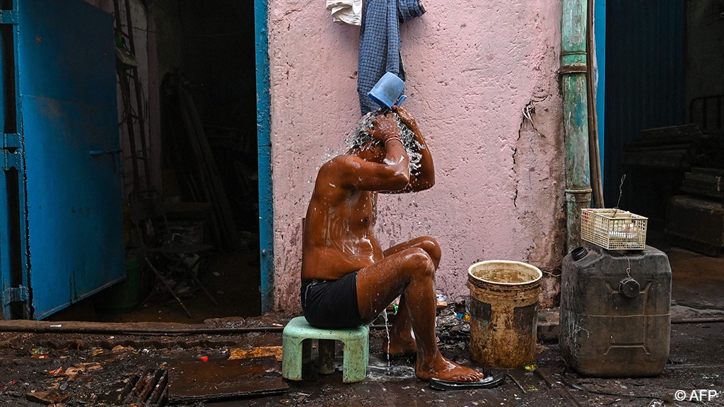 A worker bathes outside a factory in the Dharavi slums of Mumbai, where water and waste management infrastructure have not kept pace with growth (photo: Punit PARANJPE/AFP) 