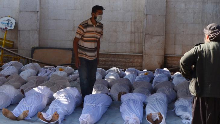 Syrische Aktivisten untersuchen die Leichen von Zivilisten die bei einem Angriff mit Nervengas im Nordosten von Damaskus starben (Foto: Reuters)