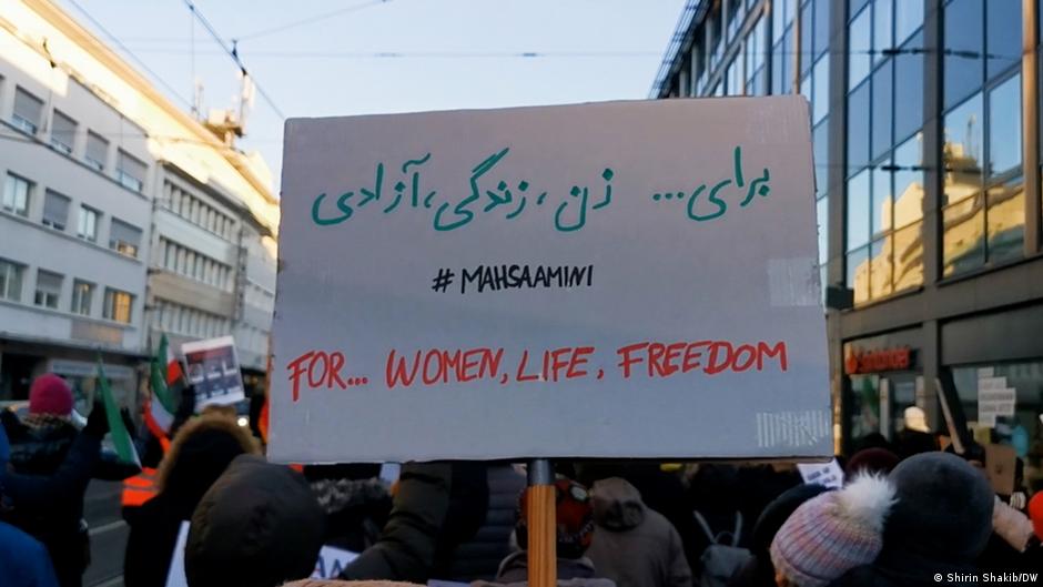 People hold up a sign that reads "For … women, life, freedom" during a demonstration of support for the protesters in Iran, Bonn, 17 December 2022 (photo: Shirin Shakib/DW)