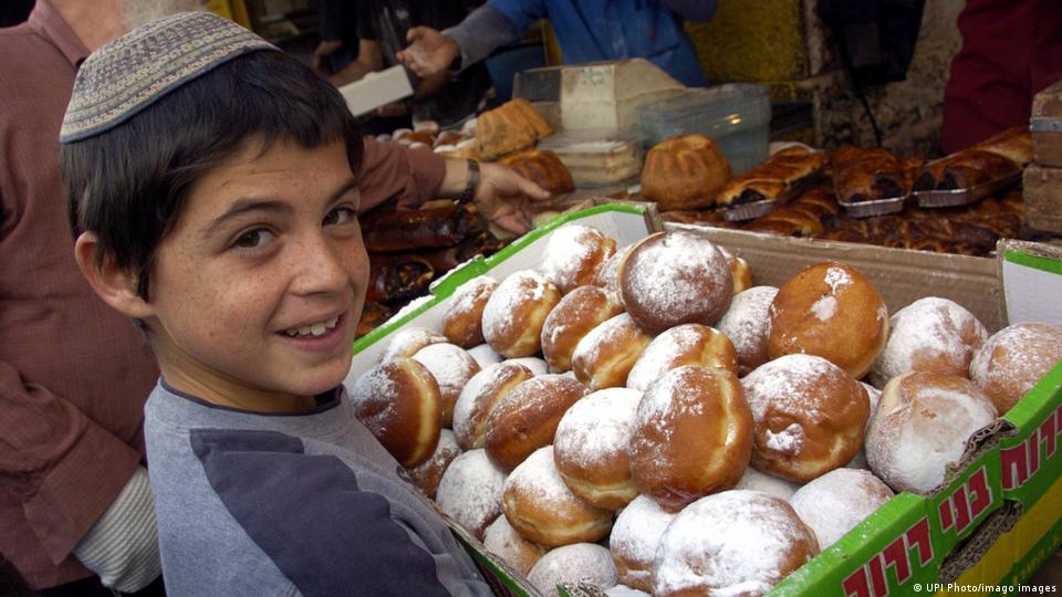 صبي يحمل كعك عيد حانوكا. Ein Junge mit Krapfen für Chanukka; Foto: UPI Images/imago