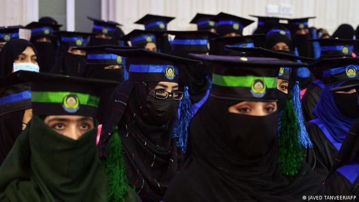 Nahaufnahme einer Gruppe Absolventinnen. Alle tragen einen Gesichtsschleier, der nur die Augen freilässt, und über dem Hidschab klassische Abschluss-Hüte.
