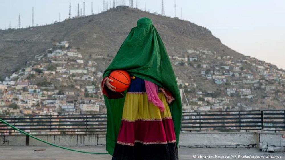 Eine junge Basketballerin steht in Burka auf einem öffentlichen Basketballlatz in Kabul.