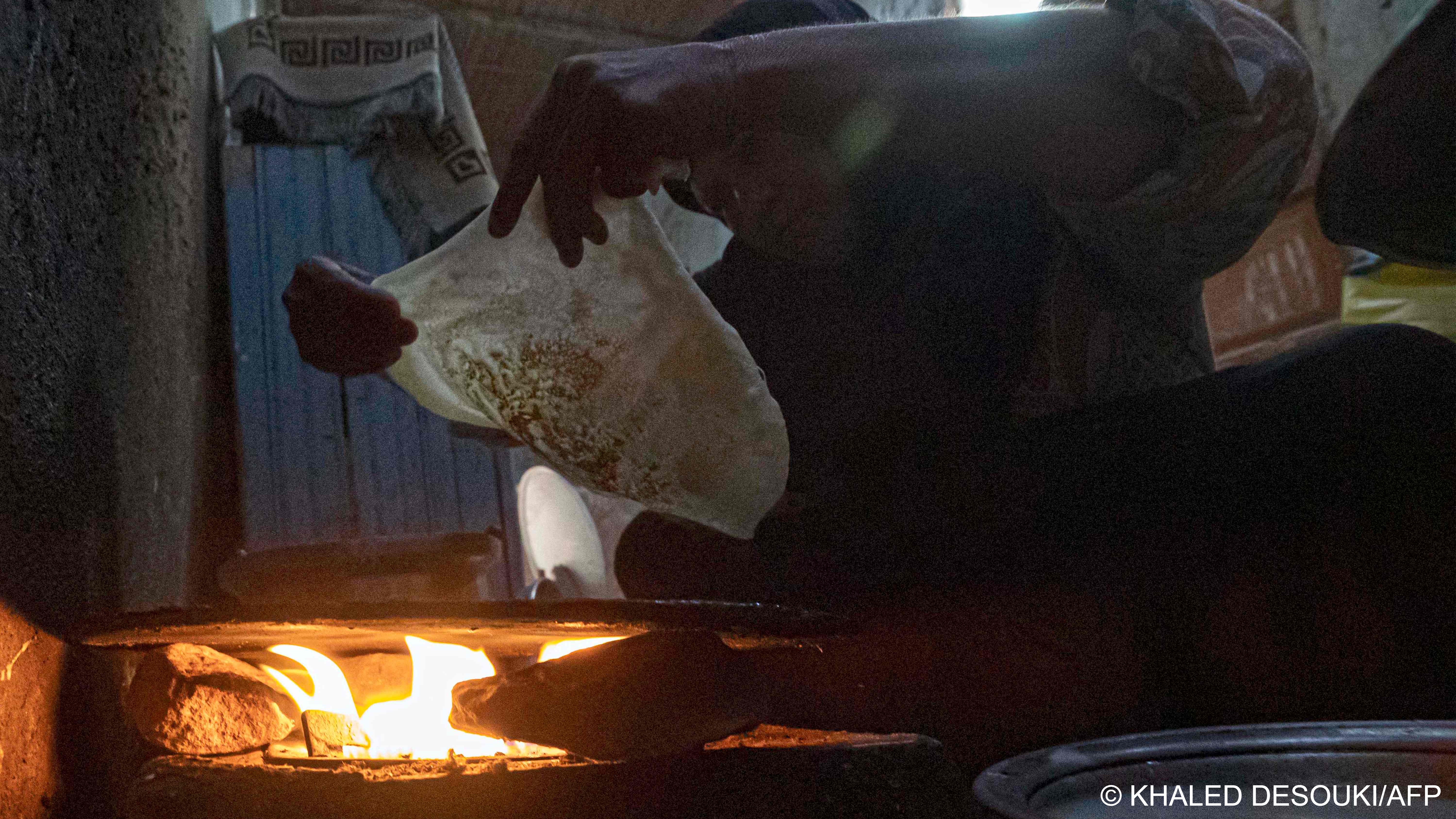 In this file photo a woman prepares traditional bread for the family at her home at Zerzara village on the west bank of the Nile river off of Egypt‘s southern city of Aswan on 26 February 2022 (image: Khaled Desouki/AFP)
