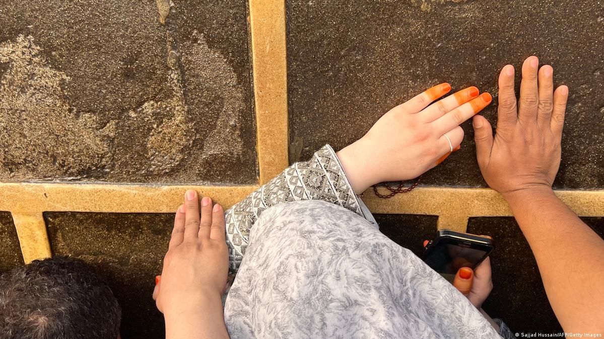 Hand und Handy: Die Umrundung der Kaaba gilt als Höhepunkt des Hadsch. Viele Pilger legen Wert darauf, das Heiligtum zu berühren. Eine Pilgerin gibt sich damit nicht zufrieden: Sie hält die Szene auch optisch, mit dem Handy fest. (Foto: Sajjad Hussain/AFP/Getty Images) 
