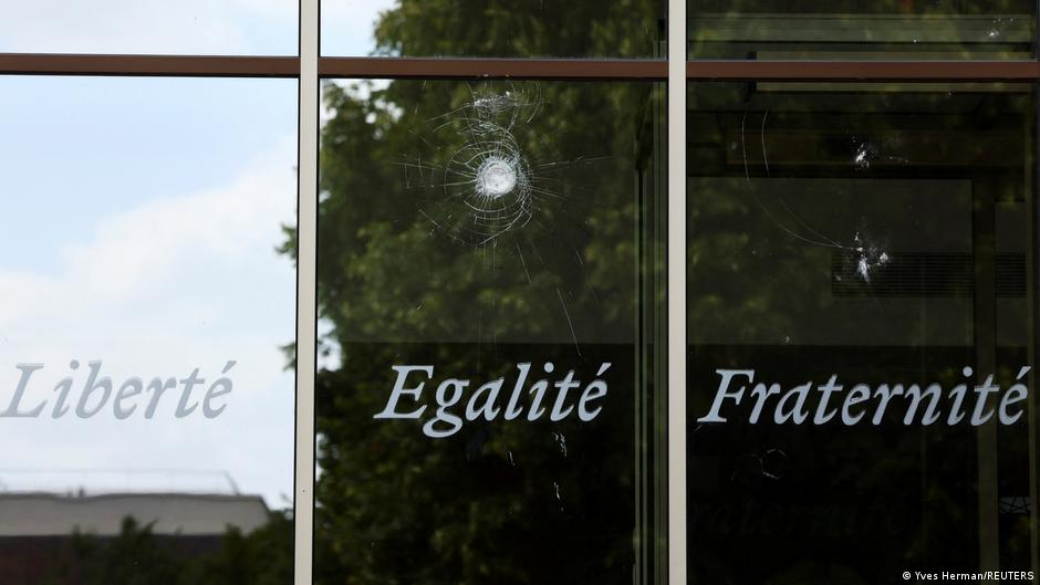 A window bearing the French motto "Liberty, equality, brotherhood"; above a hole in the glass where it has been punctured by a projectile (image: Yves Herman/REUTERS)