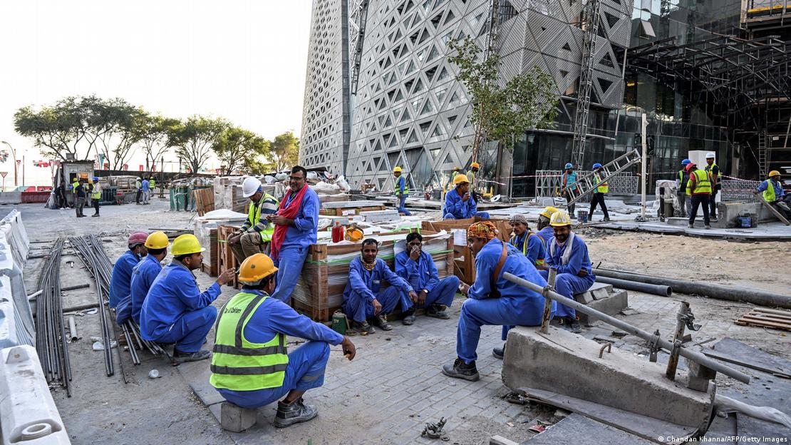 Migrant builders take a break while working at a construction site by the Corniche, Doha, 24 November 2022 (photo: Chandan Khanna/AFP/Getty Images)