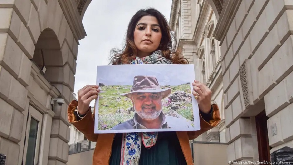 امرأة شابة ترفع في لندن صورة لداعية حماية البيئة مراد طهباز، المحتجز في سجون إيران والذي يحمل أيضا الجنسية البريطانية. (13/4/2023)