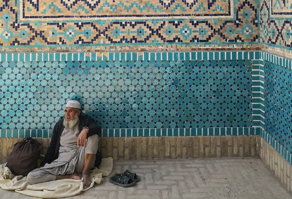 Ein Mann sitzt vor einer Kalligraphie an der Grünen Moschee von Balch; Foto: Marian Brehmer
