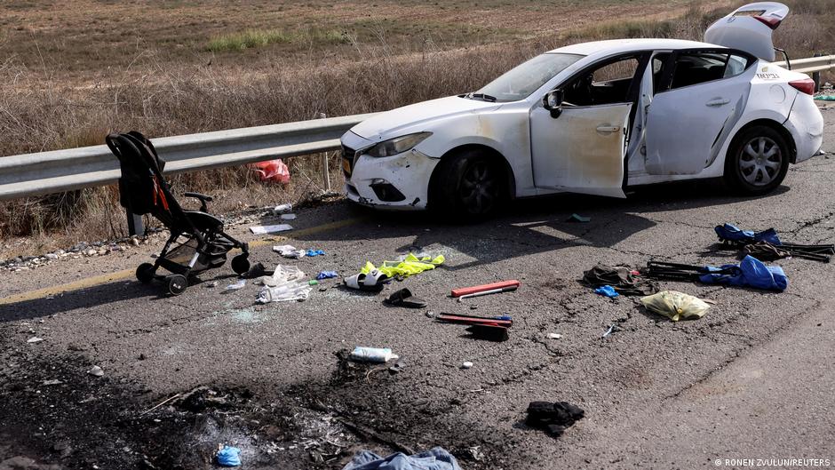 Personal belongings including a child's pram are seen on the road next to a car days after a mass infiltration by Hamas gunmen from the Gaza Strip (image: Ronen Zvulun/Reuters(