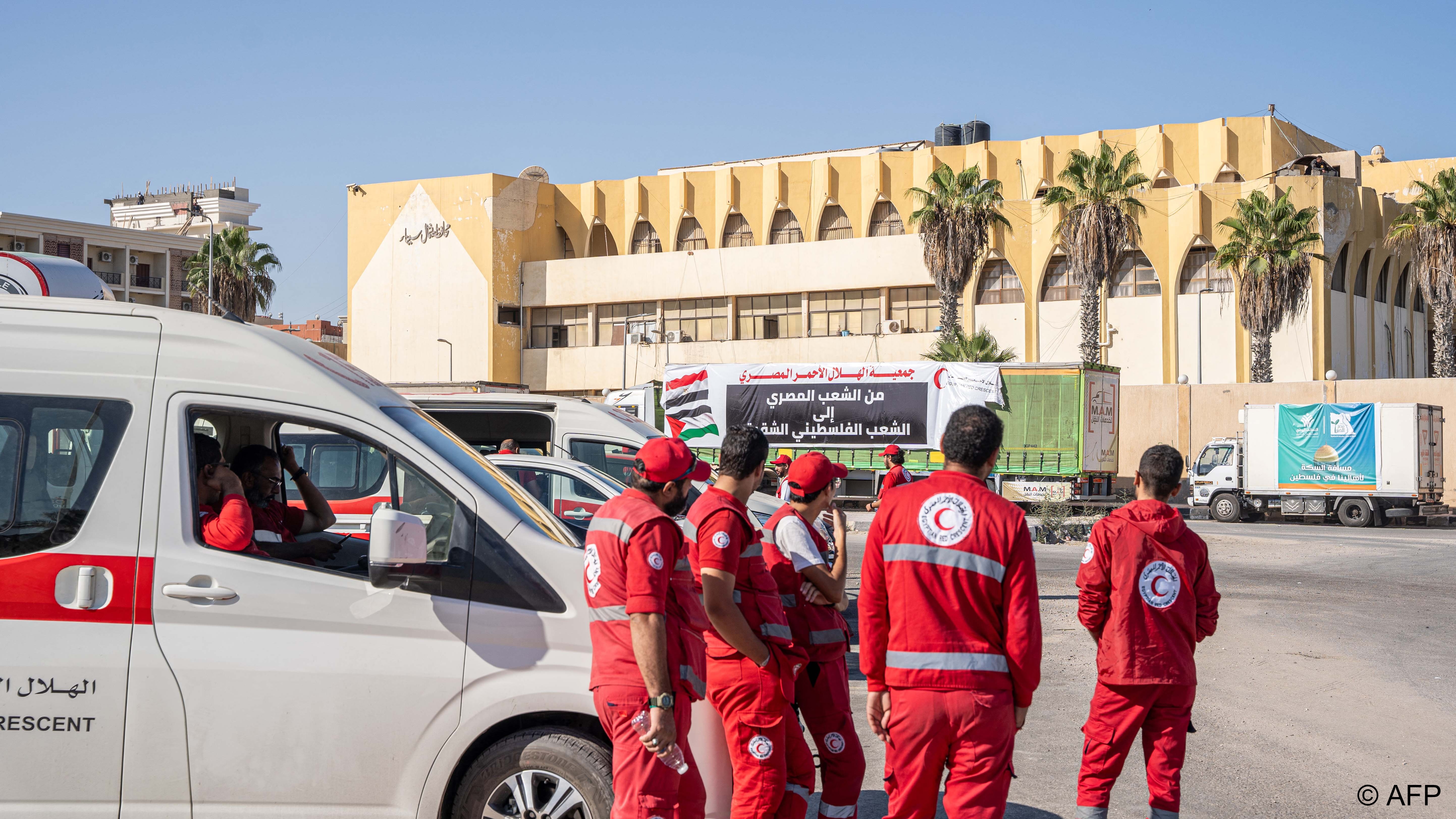 Medics and a convoy of trucks loaded with aid supplies for Gaza provided by Egyptian NGOs wait for an agreement to cross through the Egypt-Gaza border (image: Ali Moustafa / AFP)