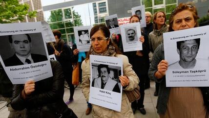 Demonstranten halten vor dem Gerichtsgebäude in München Plakate mit den Gesichtern der Opfer des NSU-Terrors hoch; Foto: Reuters/Kai Pfaffenbach