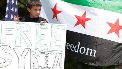 Exilsyrischer Junge in den USA hält Fahne mit der Aufschrift freies Syrien hoch; Foto: Reuters