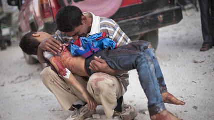 Ein Vater hält seinen von syrischen Truppen erschossenen Sohn in den Armen; Foto: AP  
