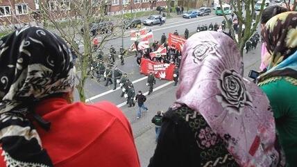 نساء مسلمات يشاهدن مظاهرة للحزب الألماني اليميني المتطرف NPD . أ ب