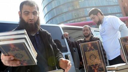 Salafisten beim Verteilen von kostenlosen Koranexemplaren in Berlin; Foto: dpa