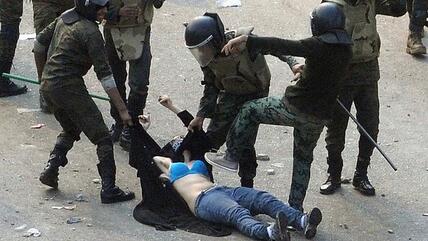 Egyptian army soldiers drag a female protester along the ground during clashes at Tahrir Square in Cairo in December 2011 (photo: Reuters)