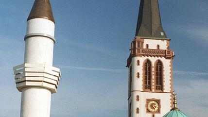 The minaret of Mannheim's Yavus Sultan Selim Mosque, next to the church spire of the "Liebrauenkirche" (photo: dpa)