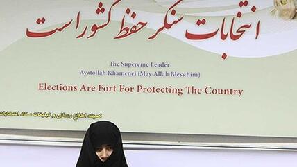 Verschleierte Frau vor Plakat mit Wahlempfehlungen Khameneis; Quelle: Mehr