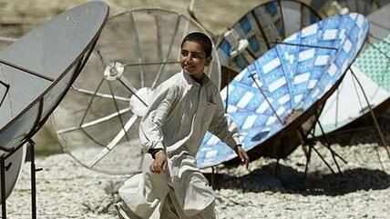 Afghanischer Junge inmitten von TV-Satellitenschüsseln in Kabul; Foto: AP