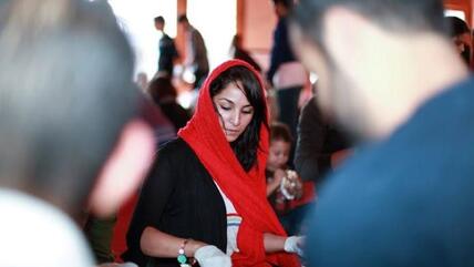 في الصورة: شابة مسلمة تحضِّر أكياس الغداء للمشردين في سان فرانسيسكو الأمريكية.