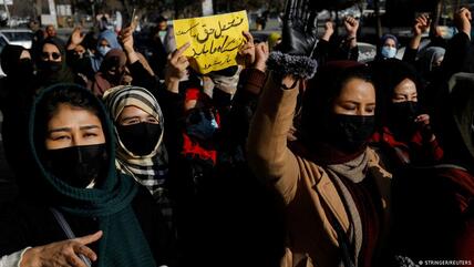 مجموعة نساء رافعات الأيدي ولافتة في مظاهرة في كابول - أفغانستان.