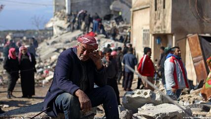 رجل يبكي وهو جالس على أنقاض مبنى منهار في بلدة جنديريس التي تسيطر عليها المعارضة السورية -  سوريا.