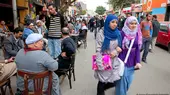Women walk past a cafe on Tahrir Square, Cairo