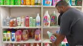 A man takes a bottle of washing detergent from a shelf in cooperative supermarket Mann wa Salwa in Beirut, Lebanon