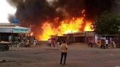 Man watches as fire rages in the market area of al-Fasher, capital of North Darfur state