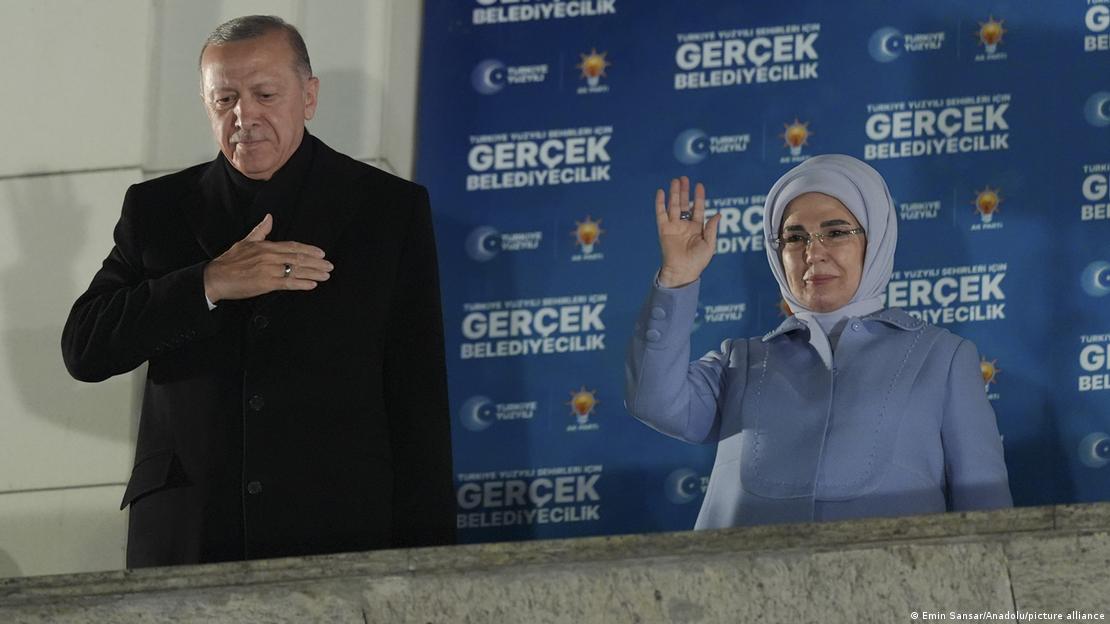 Turkey's President Recep Tayyip Erdoğan (left) acknowledges supporters from a balcony as he stands alongside his wife, Emine, at AK Party Headquarters in Ankara, Turkey on 1 April 2024   