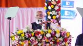 Indian Prime Minister Narendra Modi looks serious as he stands at a lectern covered in flowers