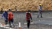 Workers carry metal bars on a construction site in Riyadh